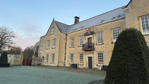 Sidewards view across a frosty garden of a large manor house